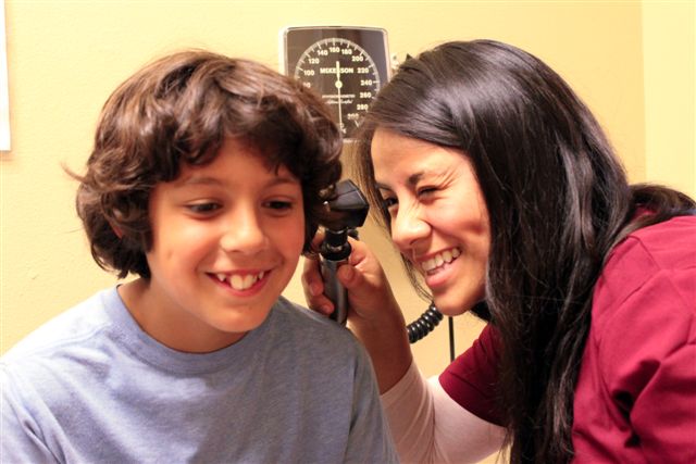 Nurse giving young boy an ear exam